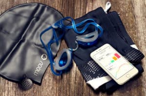 Swim equipment: swim cap, swimming trunks and goggles laid on a wooden background